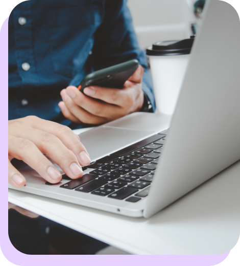man holding a phone and laptop