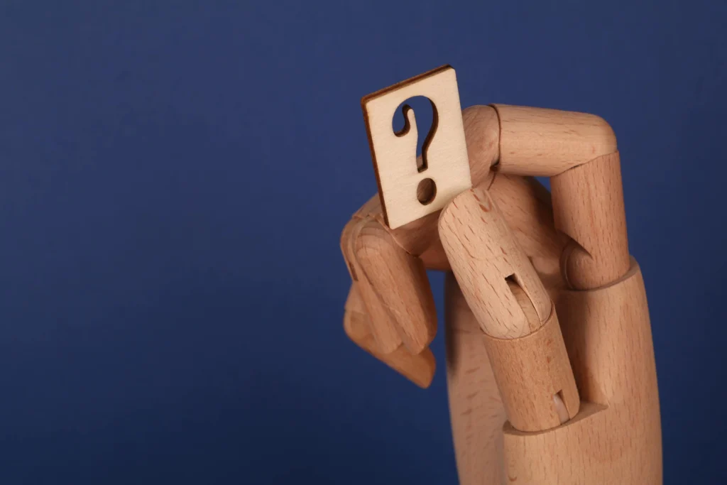 A symbolic wooden hand holding a question mark block